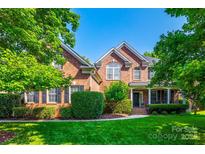 Charming brick home with lush landscaping, mature trees, and a well-manicured lawn at 8102 Bergen Ct, Waxhaw, NC 28173