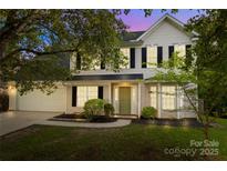 Charming two-story home with a well-manicured lawn, two-car garage, and a welcoming front porch at 11407 Lenswood Ct, Charlotte, NC 28214