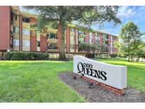 Well maintained brick apartment building featuring a large sign and mature trees in a landscaped yard at 1300 Queens Rd # 409, Charlotte, NC 28207