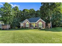 Charming brick home featuring a well-manicured lawn, mature trees, and welcoming curb appeal at 1622 Brookstone Dr, Hickory, NC 28602