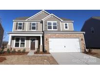Charming two-story home featuring stone accents, neutral siding, and a spacious two-car garage at 1821 Augustine St, Monroe, NC 28112