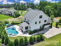 Aerial view of a large white home with a pool, hot tub, and a basketball hoop over the driveway at 2148 Nims Village Dr, Fort Mill, SC 29715