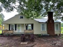 Front exterior view of house with chimney and wooden porch at 30497 Orchard Ln, Albemarle, NC 28001