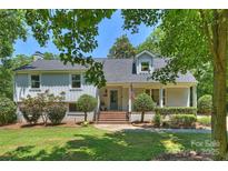 Charming two-story home with a brick and siding exterior, manicured lawn, and mature trees, creating a welcoming curb appeal at 3165 Pendleton Ave, Charlotte, NC 28210