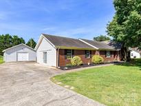 Charming red brick home with a well-manicured lawn and separate garage at 5105 Hampton Meadows Rd, Monroe, NC 28110