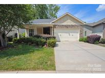 Charming home featuring a stone facade, manicured lawn, and a convenient two-car garage at 5524 Elk Knob Ct, Denver, NC 28037