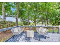 Outdoor deck with seating area overlooking scenic backyard and lake at 5728 Mantario Dr, Charlotte, NC 28269