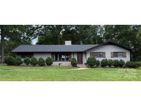 Charming brick home featuring a well-manicured lawn and lovely shrubbery at 605 Impala Dr, Albemarle, NC 28001