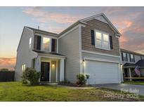 Charming two-story home with neutral siding, an attached garage, and a well-maintained lawn at 7136 Bullock Dr, Charlotte, NC 28214