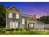 Charming two-story home featuring manicured lawn, neatly trimmed bushes, and beautiful architectural details at 9121 Four Acre Ct, Charlotte, NC 28210