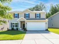 Inviting two-story home featuring a two-car garage, neutral siding, and manicured front lawn at 9123 Magnolia Lily Ave, Charlotte, NC 28227