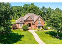 Charming brick home with a manicured lawn and lush landscaping at 1083 Fox Chase Dr, Newton, NC 28658