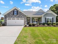 Charming single-story home with stone accents, a two-car garage, and beautifully landscaped front yard at 117 Autumn Mist Rd, Statesville, NC 28677
