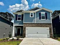 Charming two-story home featuring blue siding, brick accents, a two-car garage, and a well-maintained lawn at 1402 31St Ne St, Conover, NC 28613