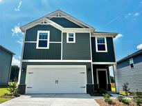 Charming two-story home featuring a two-car garage, vertical siding, and manicured landscaping against a blue sky at 1413 31St Ne St, Conover, NC 28613