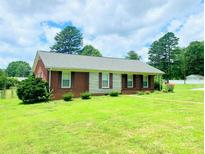 Attractive single-story home featuring a well-manicured lawn and a brick facade with a stone accent at 1901 Taylor Dr, Gastonia, NC 28052