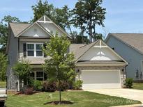 Charming two-story home featuring stone accents, a well-manicured lawn, and an attached two-car garage at 284 Old Harbor Dr, Mount Gilead, NC 27306