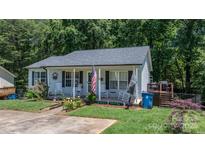 Charming single-story home with a welcoming front porch, lovely landscaping, and a gray roof at 431 Forest Dr, Maiden, NC 28650
