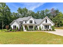 Stunning white brick home with lush landscaping and inviting front porch at 440 Bridlewood Dr, Gold Hill, NC 28071