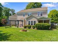 A well maintained backyard with a fire pit and seating area and lush green grass at 4408 Overbecks Ln, Waxhaw, NC 28173