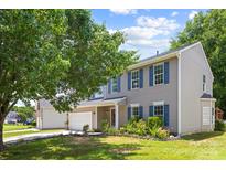 Charming two-story home with blue shutters, lush lawn, mature tree, and an attached two-car garage at 6720 Long Nook Ln, Indian Trail, NC 28079