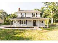 Charming two-story home with a welcoming front porch and well-maintained lawn surrounded by mature trees at 8012 Red Lantern Rd, Indian Trail, NC 28079