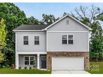 Charming two-story home with gray siding, brick accents, a two-car garage, and manicured landscaping at 8036 Joy Crossing Ln, Charlotte, NC 28214