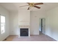 Bright living room with fireplace, ceiling fan, and neutral carpet flooring at 814 Carved Oak Ct, York, SC 29745
