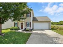Charming two-story home with an attached garage, a well-maintained lawn, and a welcoming front entrance at 8152 Chilkoot Ln, Locust, NC 28097