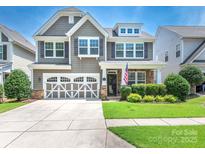 Charming two-story home with a well-manicured lawn, a two-car garage, and tasteful stone accents at 1109 Saratoga Blvd, Indian Trail, NC 28079