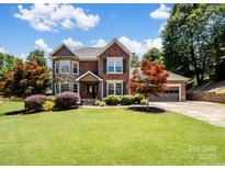 Beautiful two-story brick home with stone accents, mature landscaping, and an attached two-car garage at 165 Cottontail Se Ln, Concord, NC 28025