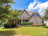 Beautiful stone facade home with a well-manicured lawn and mature landscaping in a desirable neighborhood at 17012 Alydar Commons Ln, Charlotte, NC 28278