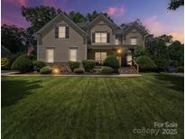 Charming two-story home featuring manicured landscaping, a welcoming front porch, and classic architectural details at 1808 Mill Chase Ln, Waxhaw, NC 28173