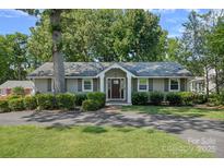 Charming home with welcoming front porch, well-maintained lawn, and mature trees at 21212 Rio Oro Dr, Cornelius, NC 28031