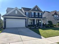 Charming two-story home featuring a well-manicured lawn, a covered front porch, and an attached two-car garage at 235 Boxelder Rd, Clover, SC 29710