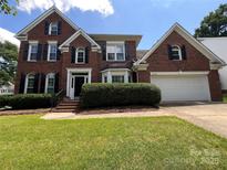 Charming brick home with black shutters, well-manicured lawn, and attached two-car garage at 2609 Lamp Post Ln, Kannapolis, NC 28081