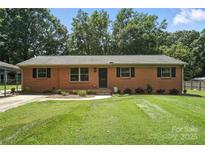 Charming brick home with a well-manicured lawn and mature trees, offering great curb appeal at 2705 Lowell Bethesda Rd, Gastonia, NC 28056