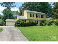 Charming two-story yellow home with a well-maintained front yard and classic black shutters at 2825 Edwin Jones Dr, Charlotte, NC 28269