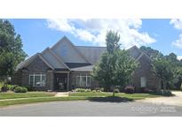 Stately brick home with mature landscaping, a manicured lawn, and a welcoming entrance at 323 Wendover Dr, Locust, NC 28097