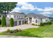 Expansive home featuring manicured landscaping, multi-car garage, and a paved driveway at 3394 Governors Island Dr, Denver, NC 28037