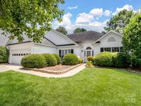 Charming one-story home with manicured lawn and lush landscaping in a suburban neighborhood at 3720 Winterberry Nw Ct, Concord, NC 28027