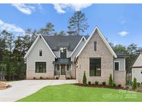 Charming two-story home with mixed brick and gray siding, lush lawn, and inviting entrance at 4069 Rivendell Rd, Denver, NC 28037