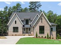 Charming two-story home with a brick and siding facade, set against a backdrop of lush greenery at 4069 Rivendell Rd, Denver, NC 28037