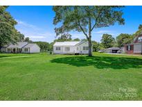 Charming single-story home with a well-maintained lawn and mature trees on a sunny day at 4555 Us 601 Hwy, Salisbury, NC 28147