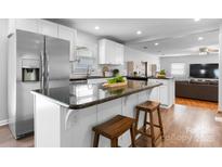 Bright kitchen with stainless steel refrigerator, black granite countertops, and white cabinets at 50 Isenhour Park Rd, Taylorsville, NC 28681