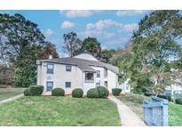 Two-story condo with manicured landscaping and a well-maintained exterior under a partly cloudy sky at 8115 Tremaine Ct, Charlotte, NC 28227