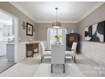 Elegant dining room features a glass table, white chairs, and decorative lighting at 9954 Mitchell Glen Dr, Charlotte, NC 28277