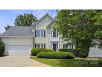 Charming two-story home with a well-maintained lawn, attached garage and dark shutters at 9954 Mitchell Glen Dr, Charlotte, NC 28277