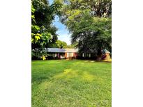 Charming brick home nestled on a lush, expansive green lawn with mature trees at 114 Huffstetler Rd, Gastonia, NC 28056
