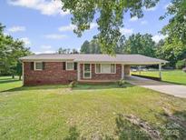 Charming brick home featuring a carport and well-maintained lawn at 197 Horseshoe Loop, Statesville, NC 28625